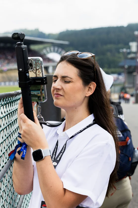 A member of the team filming on location with a smartphone on a gimbal.
